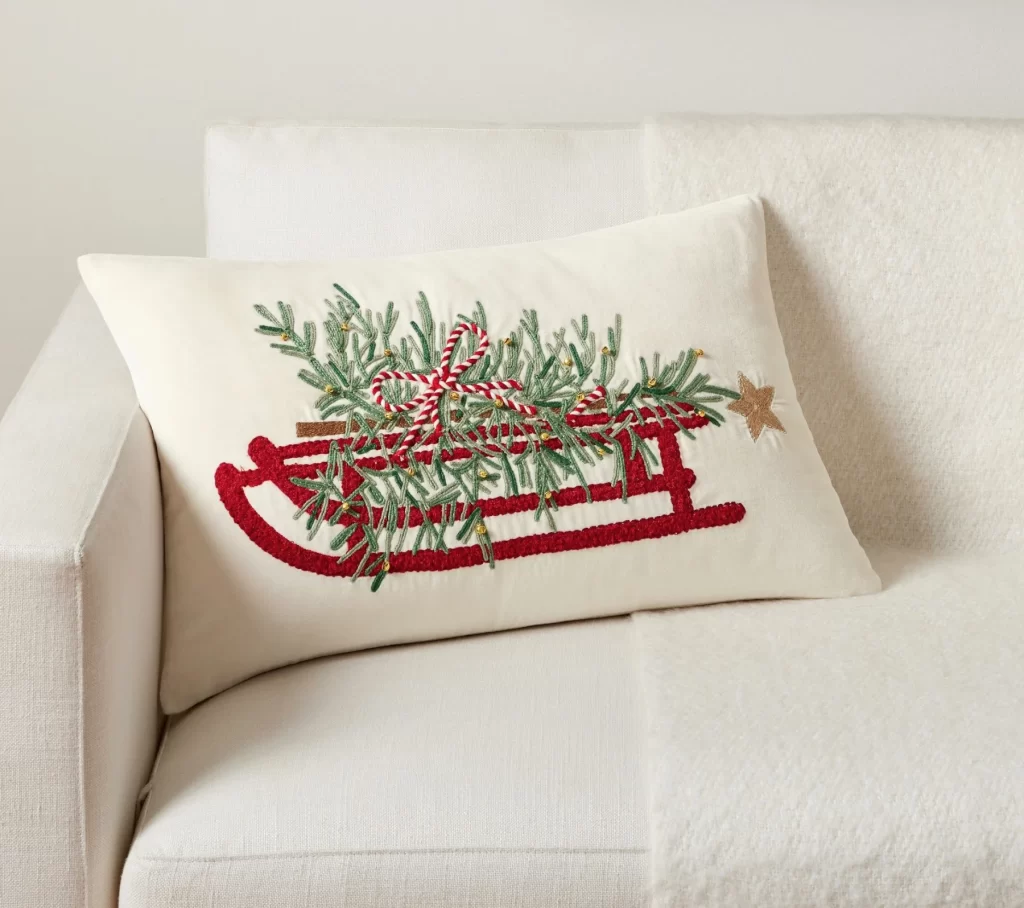 Christmas Tree Sled Embroidered Lumbar Pillow from Pottery Barn on a white sofa