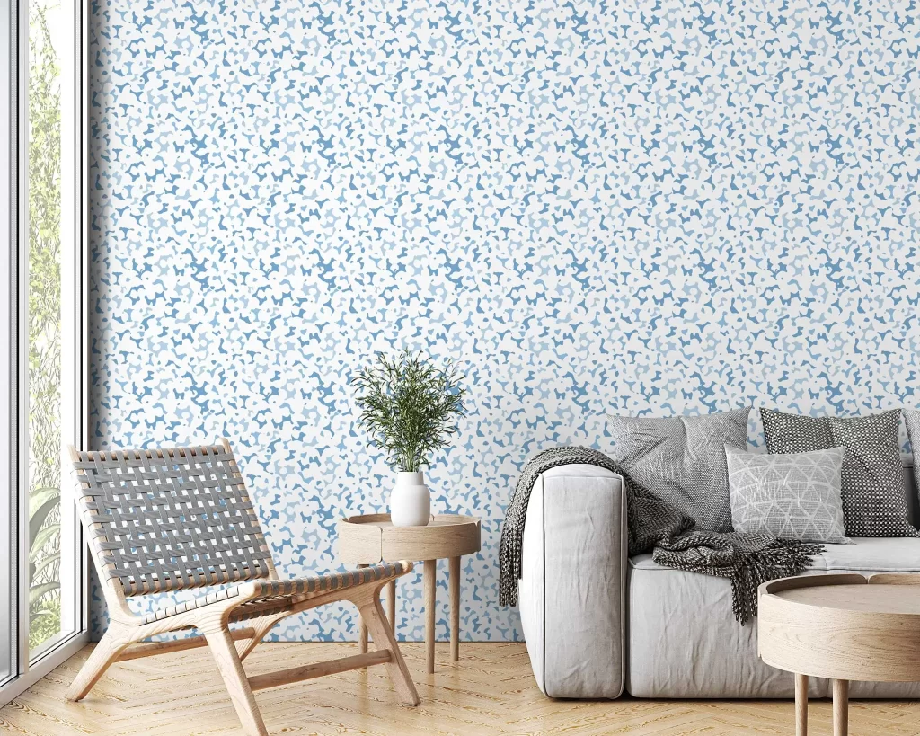Coral wallpaper in sky on a wall behind a grey sofa and modern side chair